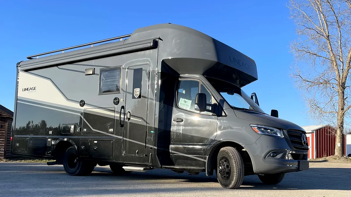 A gray Class C motorhome staged in the Jimbo yard, ready for drive-away delivery
